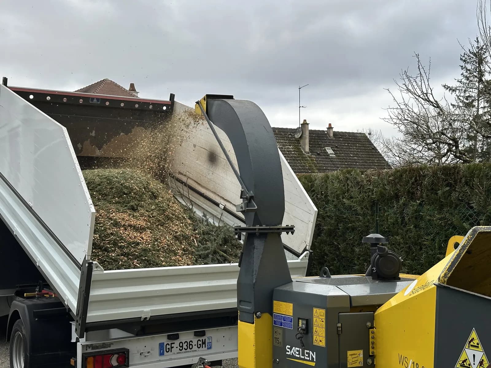 Broyeur de branches qui projette le broyat dans la benne du camion